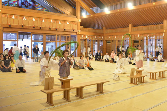 緊張した面持ちで茅の輪をくぐる参集の方々